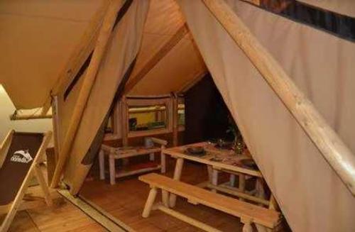 an attic room with a table and benches in it at Camping 3 étoiles - ccaiaah in Monoblet