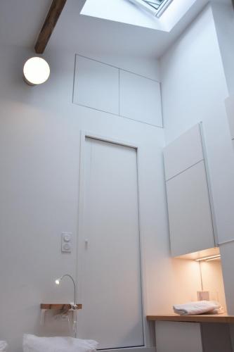 une salle de bain avec un lavabo et un miroir dans l'établissement AU COEUR de Paris AU PIED de notre Dame Studio equipe salle de bains wc calme clair type cabine clim ascenseur, à Paris