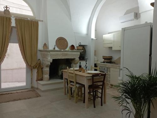 a kitchen with a table with chairs and a fireplace at B&B Sara in Tuglie