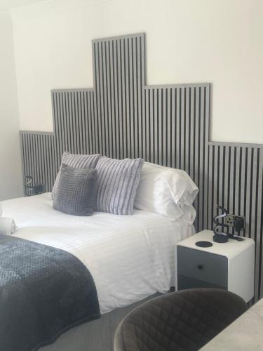 a bed with white sheets and pillows in a bedroom at Alpine Lodge Guest House in Llanberis