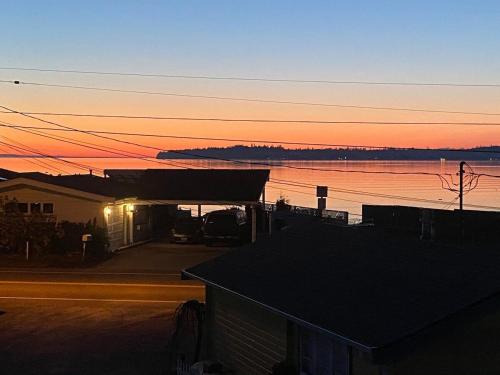 Blick auf ein Gebäude mit Sonnenuntergang im Hintergrund in der Unterkunft 2nd story 1 bed apt #3 with kitchenette and a sweeping view of Birch Bay in Blaine