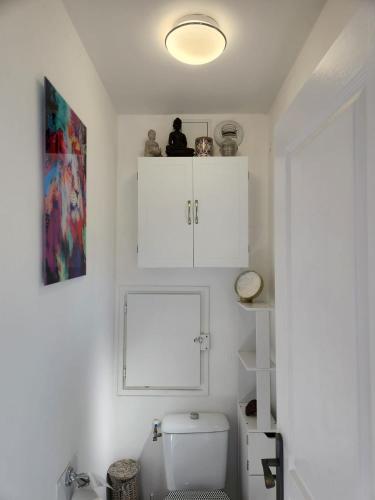 La salle de bains est pourvue de toilettes et de placards blancs. dans l'établissement Évasion en Côte d'Azur - Mazet Cosy - Restanques, à Grimaud