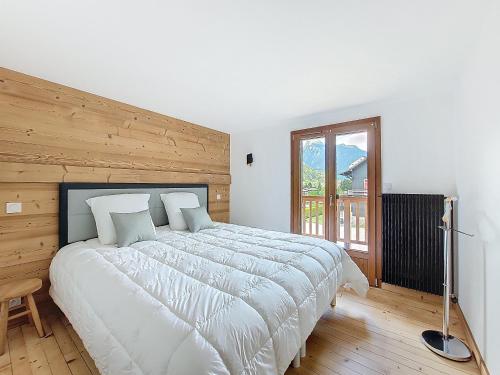 une chambre avec un grand lit avec un mur en bois dans l'établissement Chalet Alpa, à Morzine
