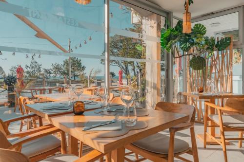 a dining room with a long table and chairs at Hôtel Édenia - Spa Estime&Sens in Carnac