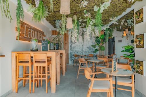 a restaurant with tables and chairs and plants at Hôtel Édenia - Spa Estime&Sens in Carnac