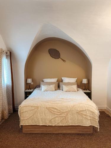 a bedroom with a large bed with an arched ceiling at Cosy Cœur Alpilles, T2 neuf in Aureille