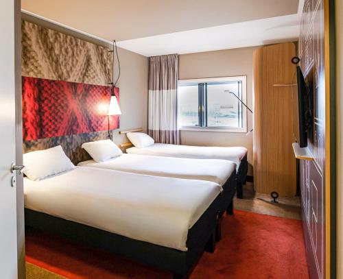 a hotel room with two beds and a window at ibis Manchester Centre 96 Portland Street in Manchester