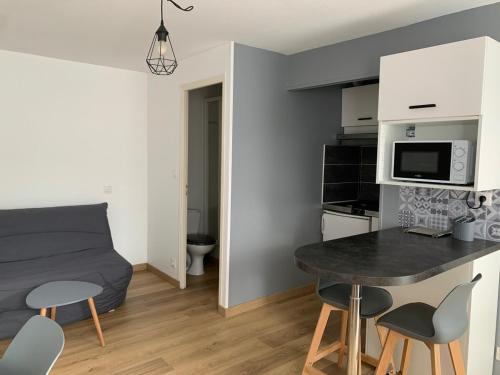 une petite pièce avec un lit, une table et des chaises dans l'établissement ღ Le Spot - Studio Proche Océan & Parking, à La Rochelle