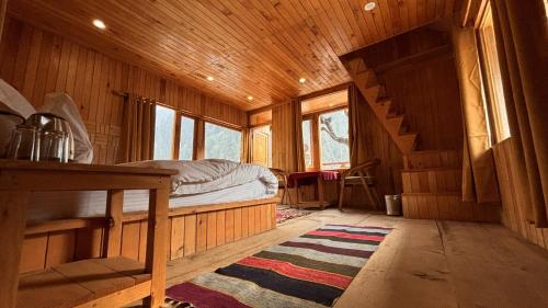 a bedroom with a bed in a wooden cabin at The mysteryworld a-wooden tree cottage jibhi in Banjār