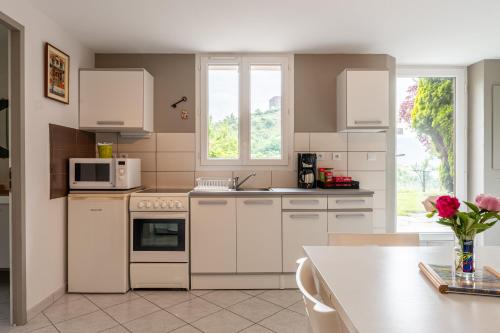 une cuisine avec des appareils électroménagers blancs et une table avec des fleurs dans l'établissement Appartement T2, à Hermillon
