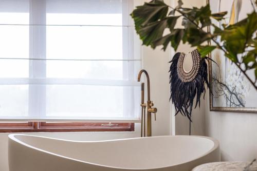 a bath tub in a bathroom next to a window at Luxurious Arakana Villa with Pool in Jimbaran
