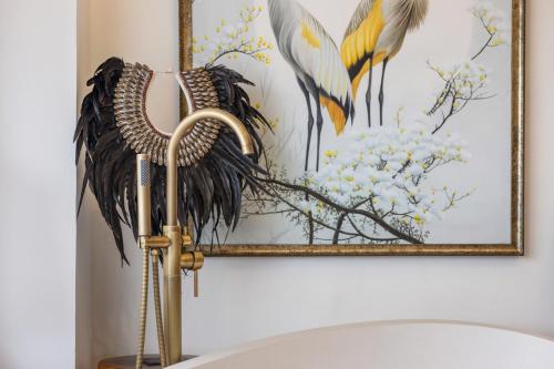a bathroom with a picture of birds on the wall at Luxurious Arakana Villa with Pool in Jimbaran