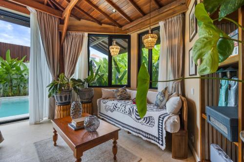 a living room with a couch and a table at Luxurious Arakana Villa with Pool in Jimbaran