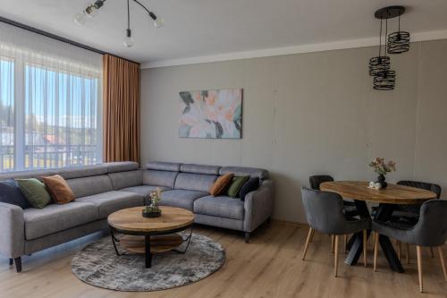 a living room with a couch and a table at Brezovina Deluxe apartmán B209 in Námestovo