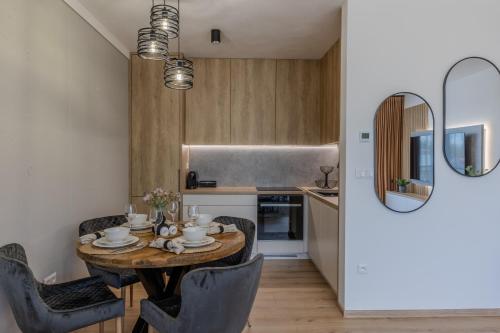 a kitchen and dining room with a wooden table and chairs at Brezovina Deluxe apartmán B209 in Námestovo