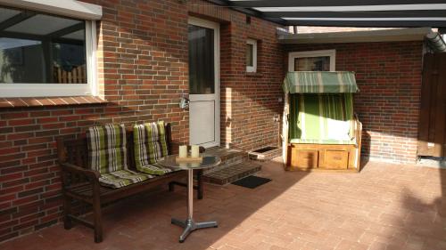 a patio with a table and chairs next to a brick building at Apartment an der Fehnroute in Leer