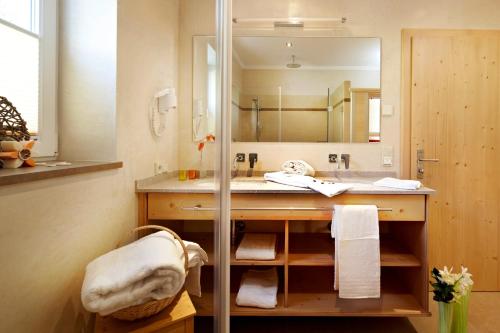 y baño con lavabo y espejo. en Alpenhof Apartments, en Mittersill