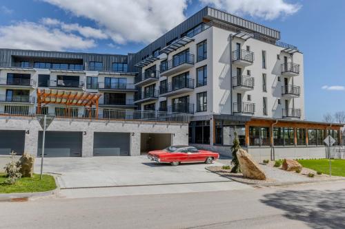 a red car parked in front of a building at Brezovina Deluxe apartmán B209 in Námestovo