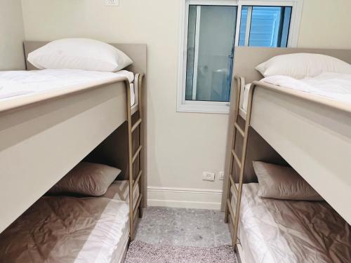 two bunk beds in a room with a window at Prince Palace Hadera Beach Resort in H̱adera
