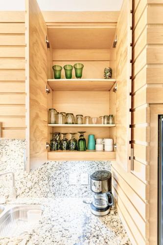 a kitchen with wooden cabinets and shelves with green pots at ANANA El Dorado 203 | Condo with Lake views & Pool in Ajijic