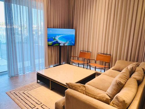 a living room with a couch and a flat screen tv at Prince Palace Hadera Beach Resort in H̱adera