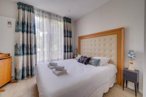 une chambre avec un grand lit blanc et une fenêtre dans l'établissement Magnifique maison à Bordeaux, à Bordeaux