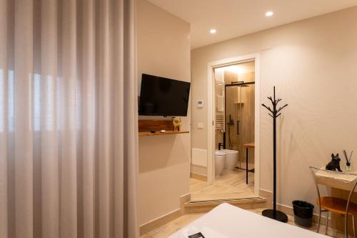 a living room with a television and a bathroom at Al Primo Vico in Matera