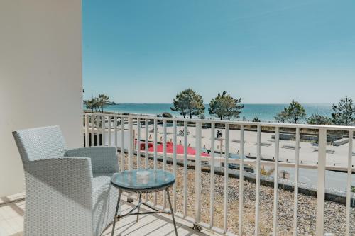 a balcony with a table and chairs and the ocean at Hôtel Édenia - Spa Estime&Sens in Carnac