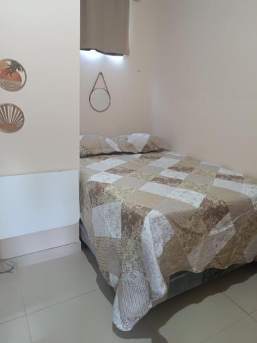 a bedroom with a bed with a quilt on it at Suite das Mangueiras I in Soure