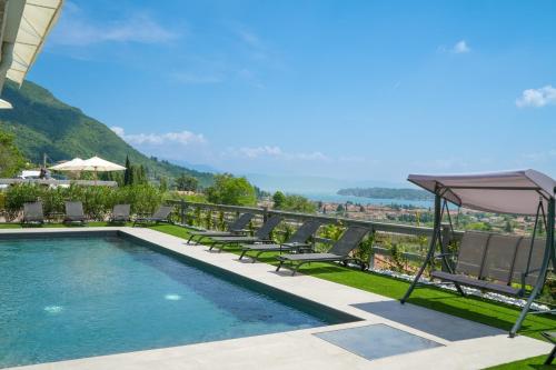 a swimming pool with chaise lounge chairs and an umbrella at Hotel Vita in Salò