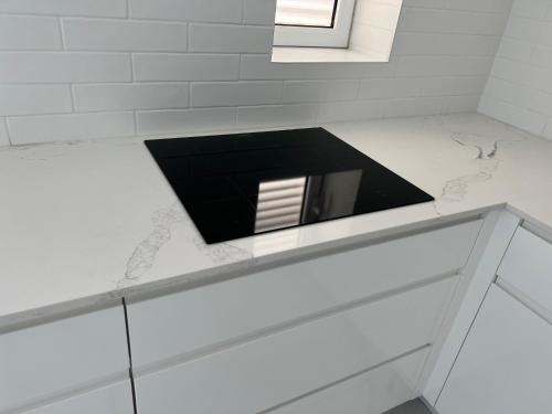 a white bathroom with a black counter top at Prince Palace Hadera Beach Resort in H̱adera