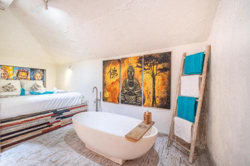 a bathroom with a bath tub and a bed at Rainbow Family Bungalow, Your Cozy Base for Sumba Adventures in Lakahembi