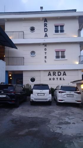 two cars parked in front of a hotel at Hotel Arda Bali in Negara