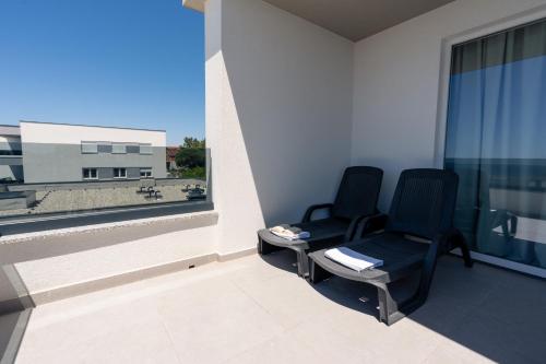 a room with two chairs and a large window at Boutique Hotel IVY'Z in Novalja