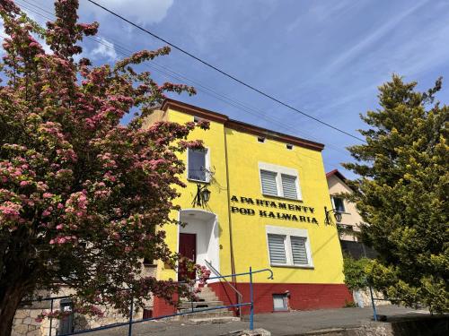 a yellow building with a sign on it at Apartamenty Pod Kalwarią Góra Św Anny in Góra Świętej Anny