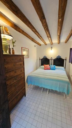 a bedroom with a bed and a wooden dresser at La Casa di Nonna Ida in Stromboli