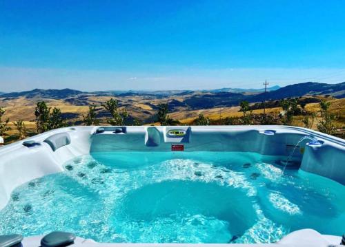 a jacuzzi tub with a view of the desert at MonteSoprano Agriturismo - Resort - Spa - Gym -Camping - Suite in Capizzi