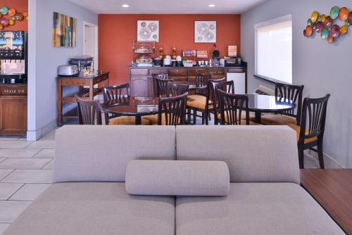 een woonkamer met een bank en tafels en stoelen bij Americas Best Value Inn - Batesville in Batesville
