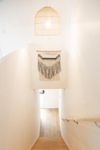 a room with a staircase with a rug hanging from the ceiling at Coastal Escape Watch Horses Pass Walk to Beach in Redcliffe