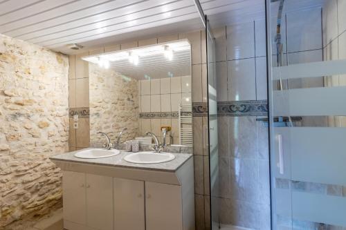 a bathroom with two sinks and a glass shower at Chambre Bleuet in Auriac-du-Périgord