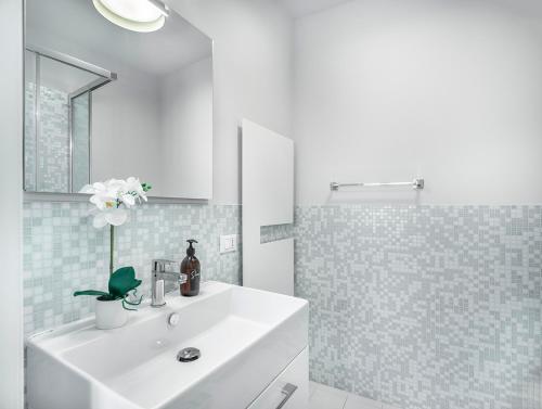 a white bathroom with a sink and a shower at Biennale Palace R&R in Venice