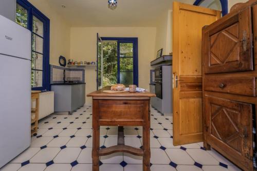 a kitchen with a table in the middle of a room at L'Aile Est in Mayac