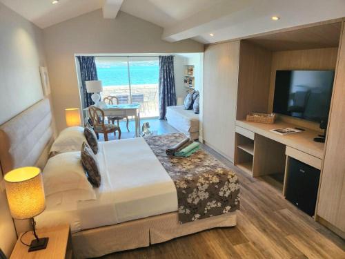 a hotel room with a bed and a desk with a television at La Belle Aurore in Sainte-Maxime