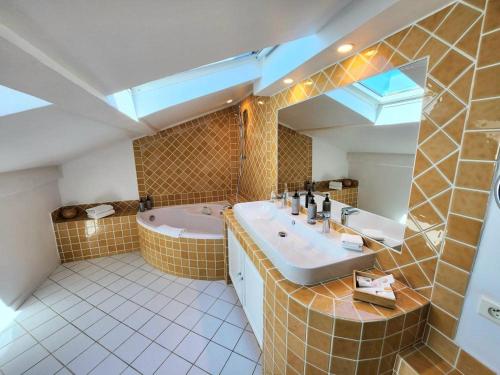 a bathroom with a tub and a sink and a mirror at La Belle Aurore in Sainte-Maxime