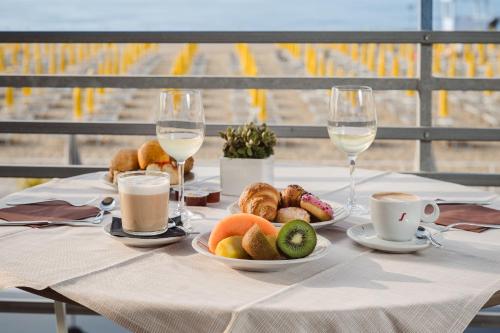 a table with plates of food and glasses of wine at Hotel Las Vegas in Lido di Jesolo