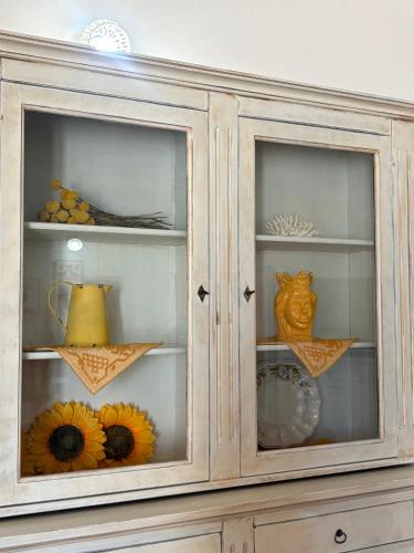 a wooden cabinet with vases and flowers in it at Orosei Summer Holidays - Cala del Turco green house in Orosei