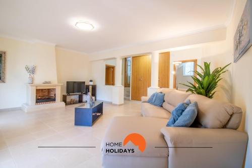 Una sala de estar con un sofá y un televisor en #297 Moderna V3 com Piscina by Home Holidays, en Albufeira