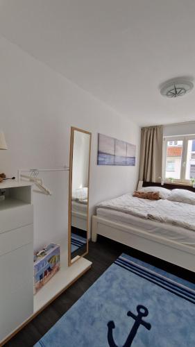 a bedroom with a mirror and a bed and a rug at Ostseeeule in Graal-Müritz