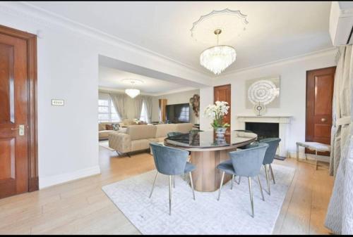 a living room with a table and blue chairs at CARLTON COURT - MAYFAIR in London