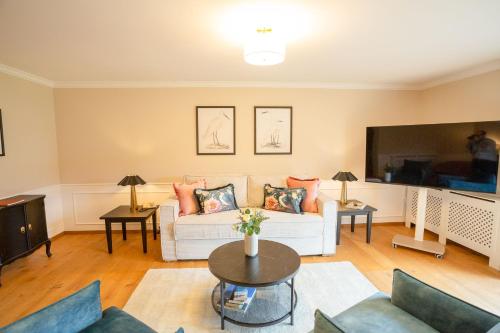 a living room with a white couch and a tv at Seewirt in Zell am Moos
